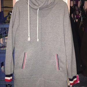 Grey sweater with red, white, blue pockets.